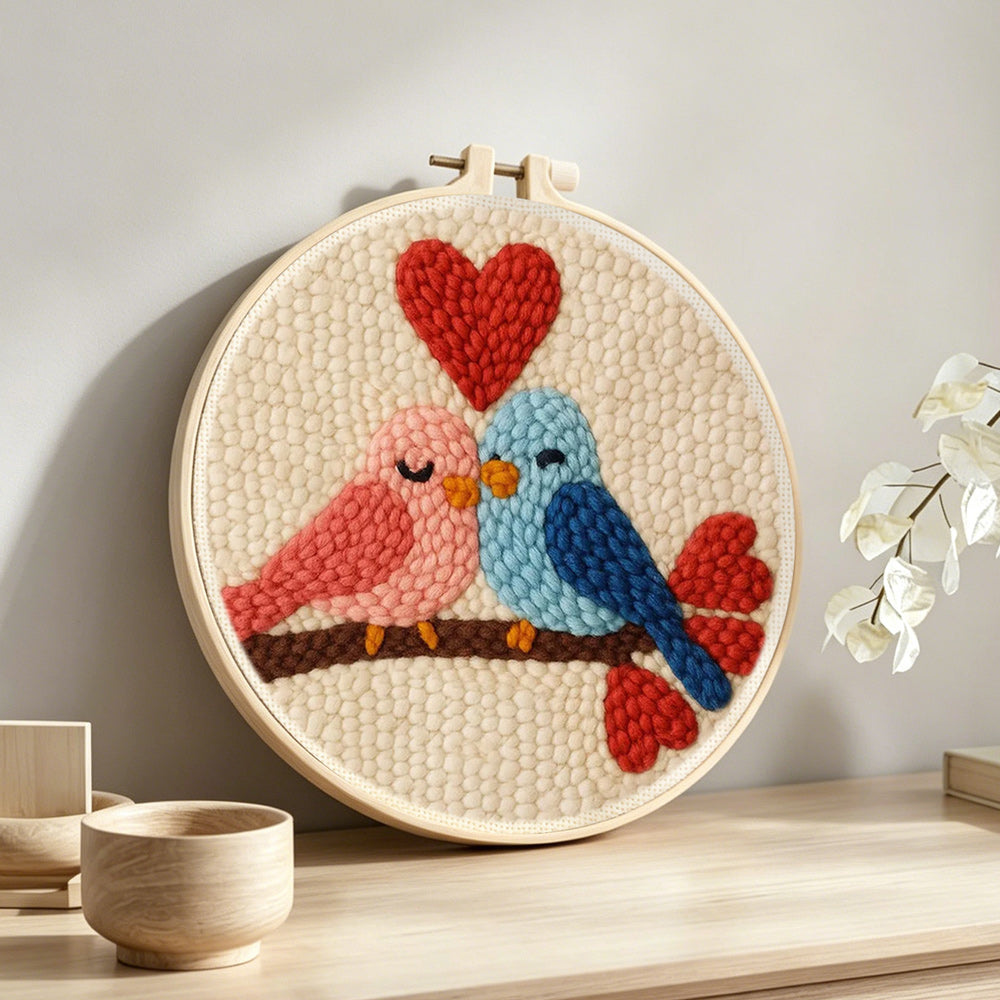 Lovebirds and hearts punch needle artwork displayed on a table