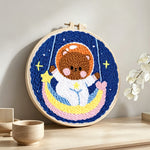 Lovely space bear on a moon swing punch needle artwork displayed on a table