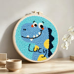 Lucky blue dinosaur punch needle artwork displayed on a table