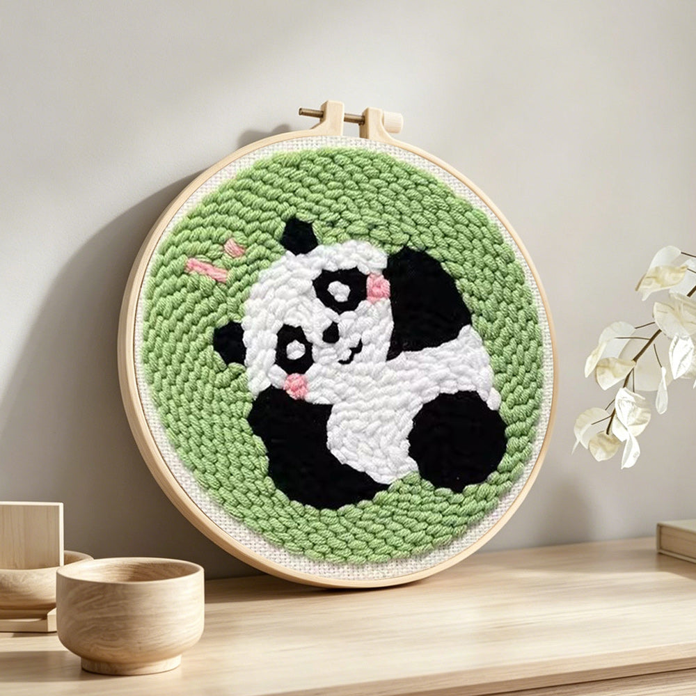 Lying panda punch needle artwork displayed on a table