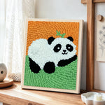 Lying panda with bamboo punch needle artwork displayed on a table
