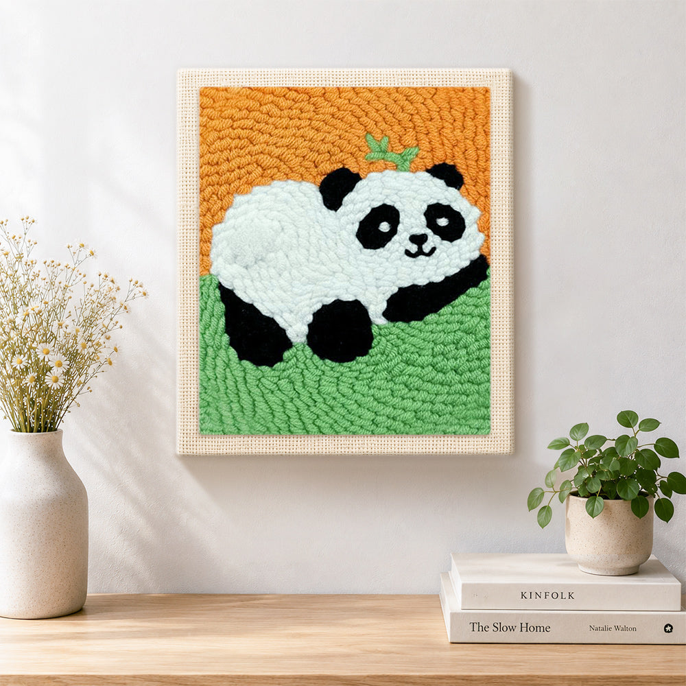 Finished lying panda with bamboo artwork displayed on a wall
