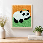 Finished lying panda with bamboo artwork displayed on a wall