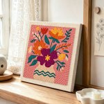 Magenta and orange bouquet punch needle artwork displayed on a table