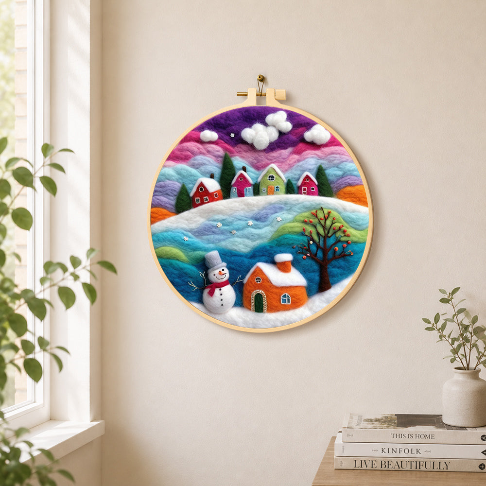 Magical rainbow snowy village at christmas needle felt wall art displayed in a bright home interior