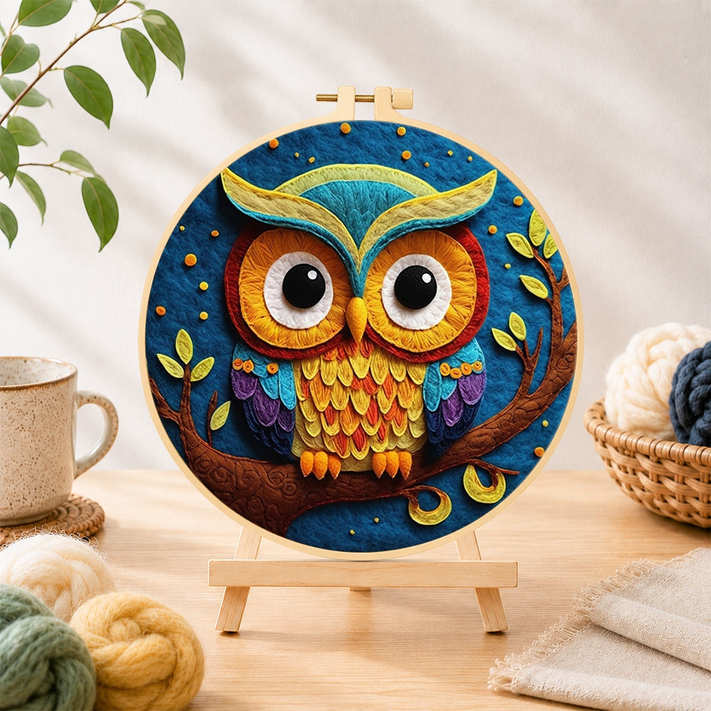 Finished majestic rainbow owl on a branch needle felting displayed on a wooden easel