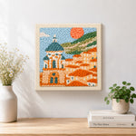 Finished mediterranean coastal town artwork displayed on a wall