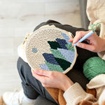 Creating handmade minimal mountain landscape with moon punch needle artwork