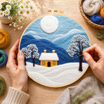 Creating the minimalist blue mountains and snowy house wool painting by hand with a felting needle