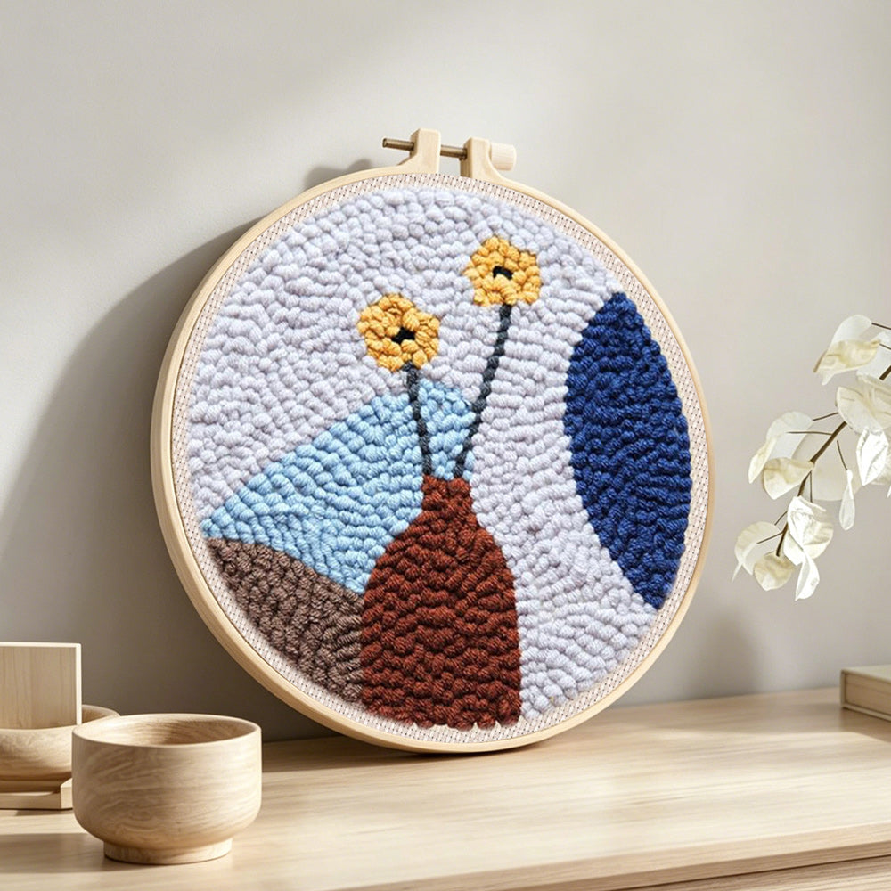 Minimalist flower arrangement punch needle artwork displayed on a table
