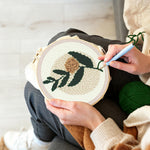 Creating handmade minimalist green leaves and beige flower punch needle artwork