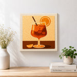 Finished minimalist orange cocktail with straw and citrus artwork displayed on a wall