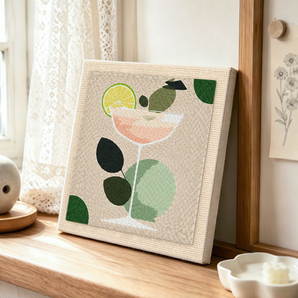 Minimalist peach cocktail with lime punch needle artwork displayed on a table