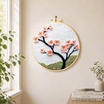 Minimalist pink flower branch needle felt wall art displayed in a bright home interior