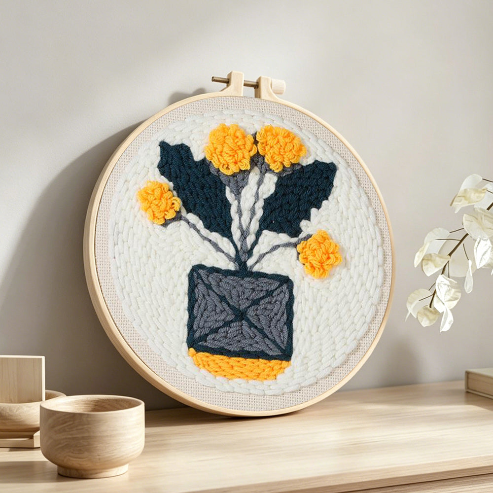 Minimalist potted yellow flowers punch needle artwork displayed on a table