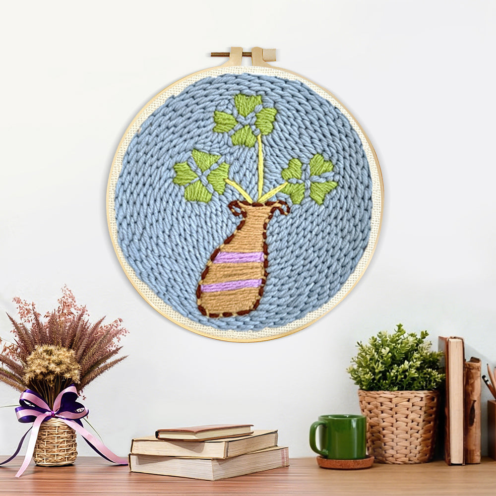 Finished minimalist vase and leaves artwork displayed on a wall