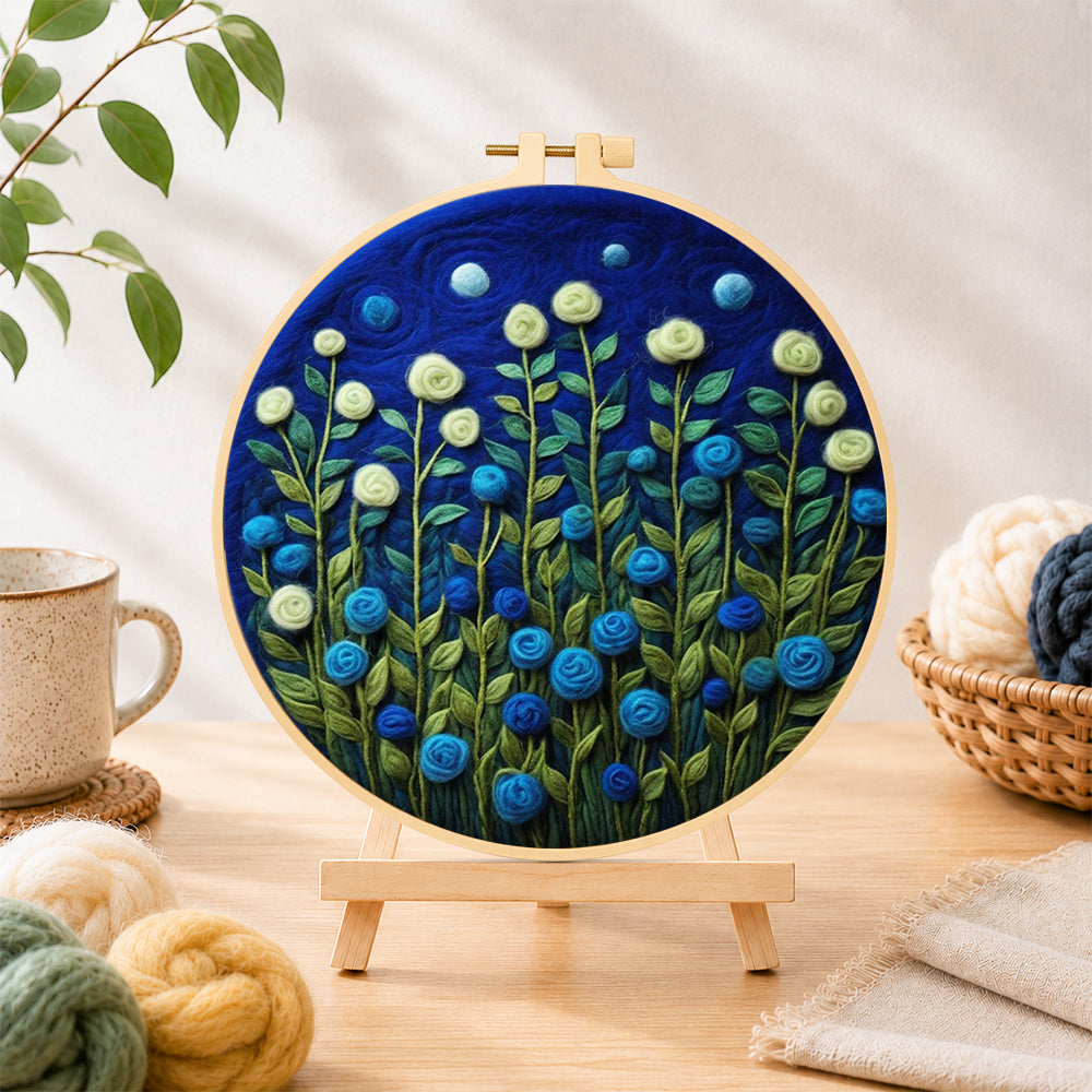 Finished mint green and blue roses at night needle felting displayed on a wooden easel