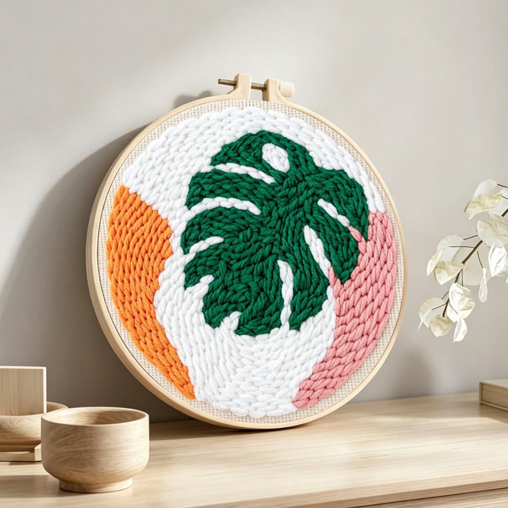 Modern monstera leaf punch needle artwork displayed on a table