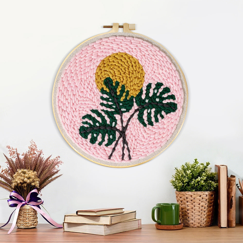 Finished monstera leaf and golden sun artwork displayed on a wall