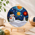 Finished moon and snowman under the starry sky needle felting displayed on a wooden easel