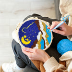 Creating handmade moon and starry night over mountains punch needle artwork