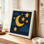 Moon and stars punch needle artwork displayed on a table
