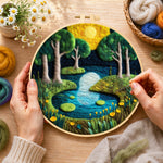 Creating the moonlit forest lake wool painting by hand with a felting needle