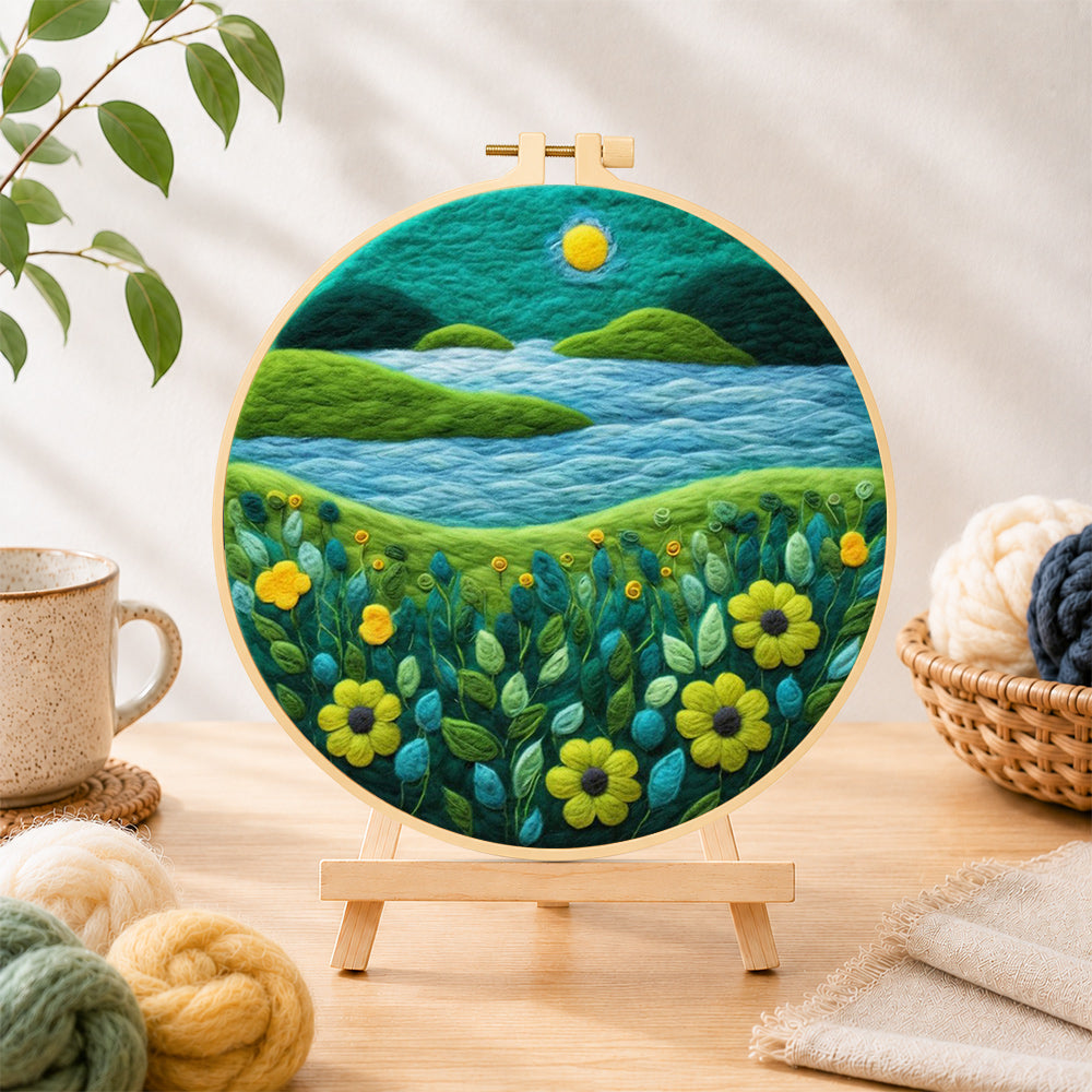 Finished moonlit river scene with bright flowers needle felting displayed on a wooden easel