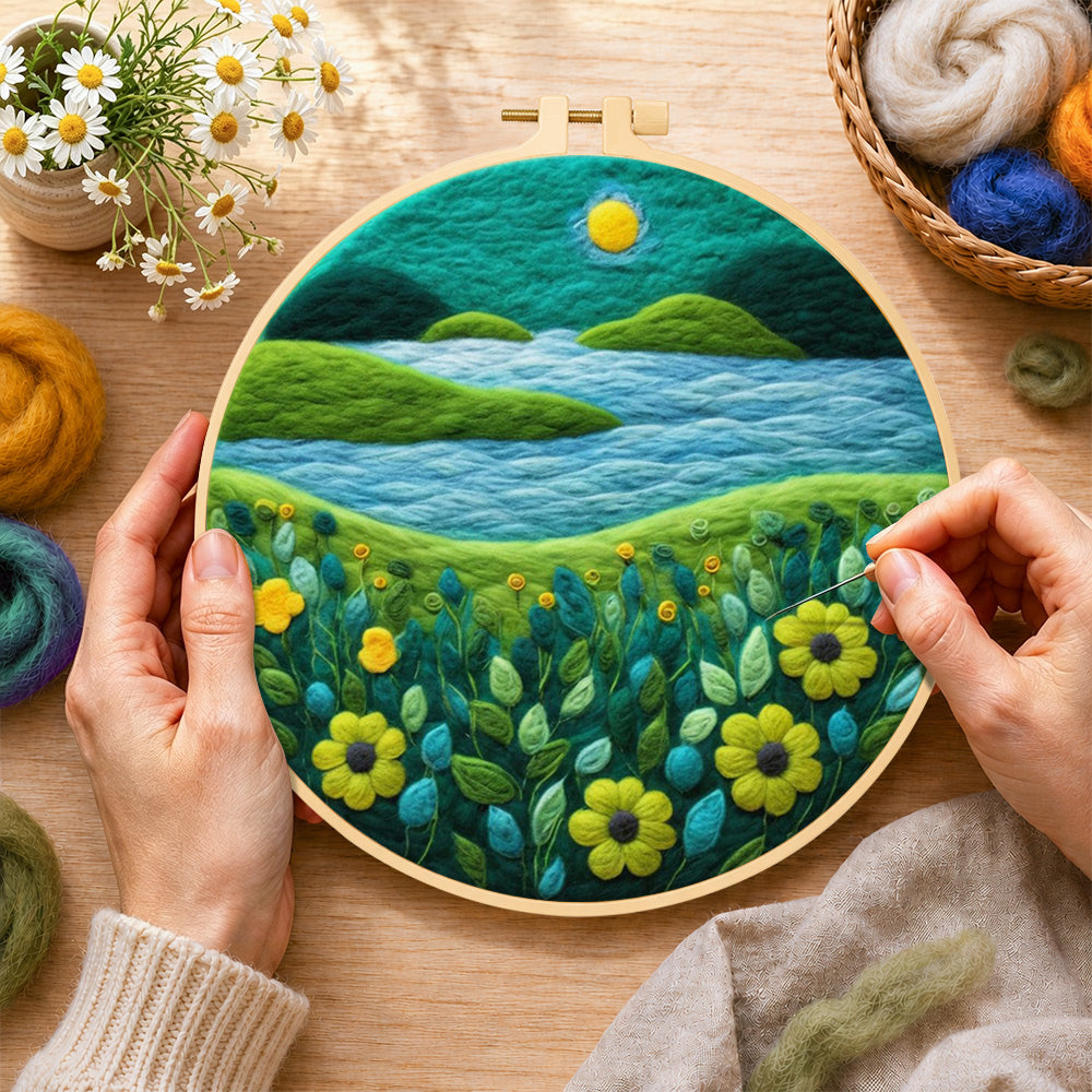 Creating the moonlit river scene with bright flowers wool painting by hand with a felting needle
