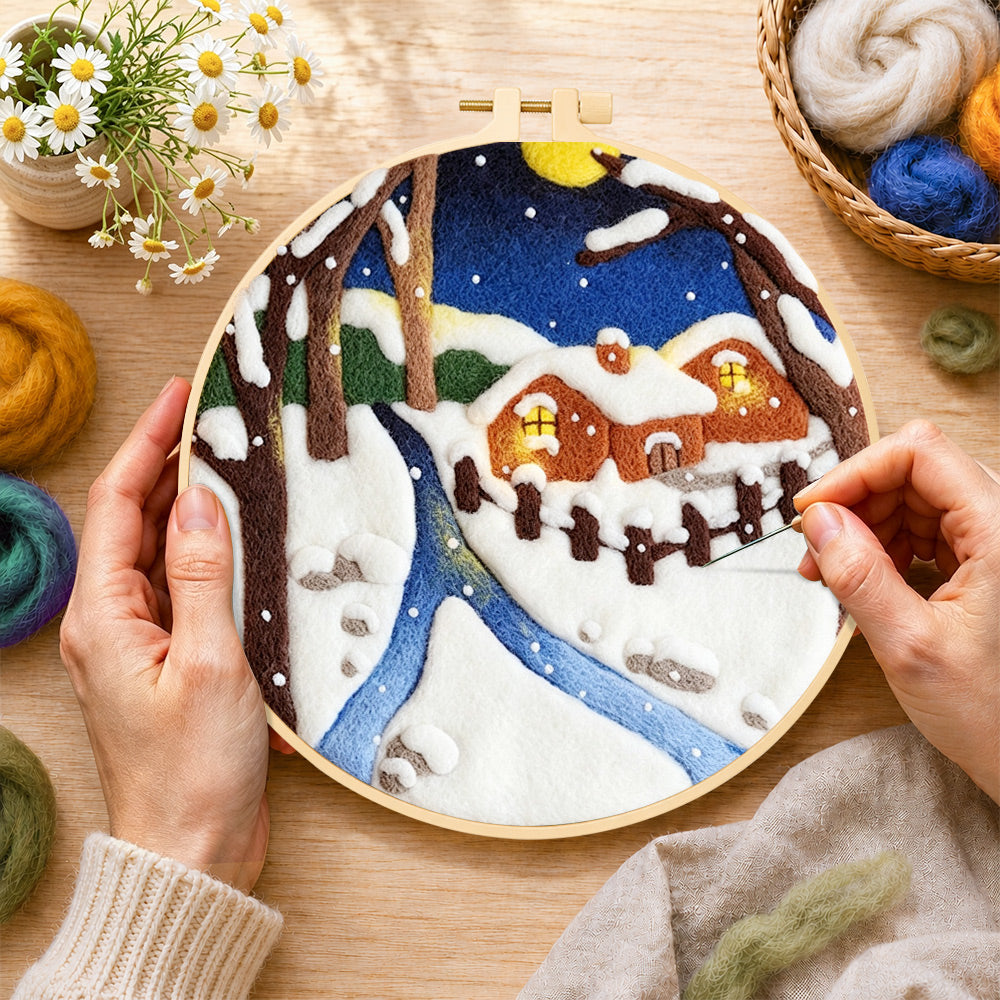 Creating the moonlit snowy cabin with warm glow wool painting by hand with a felting needle