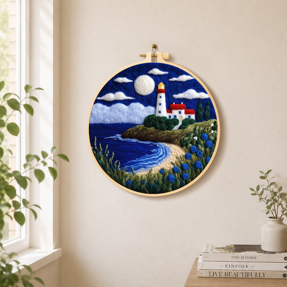Moonlit white lighthouse and blue roses needle felt wall art displayed in a bright home interior