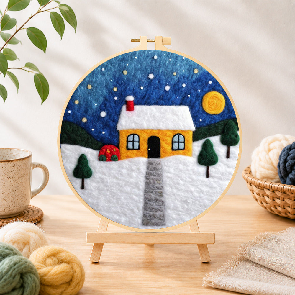 Finished moonlit yellow house and red bushes needle felting displayed on a wooden easel
