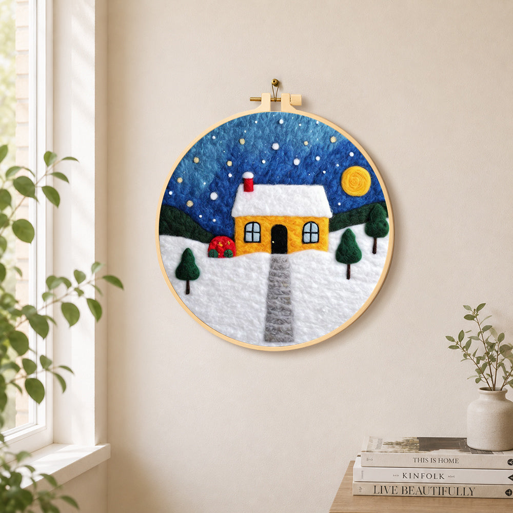Moonlit yellow house and red bushes needle felt wall art displayed in a bright home interior