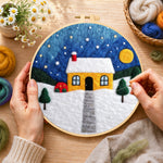 Creating the moonlit yellow house and red bushes wool painting by hand with a felting needle