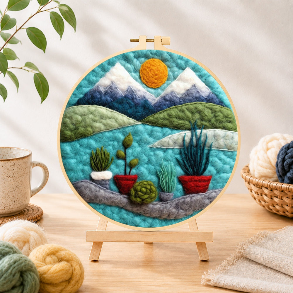 Finished mountain and potted plants needle felting displayed on a wooden easel