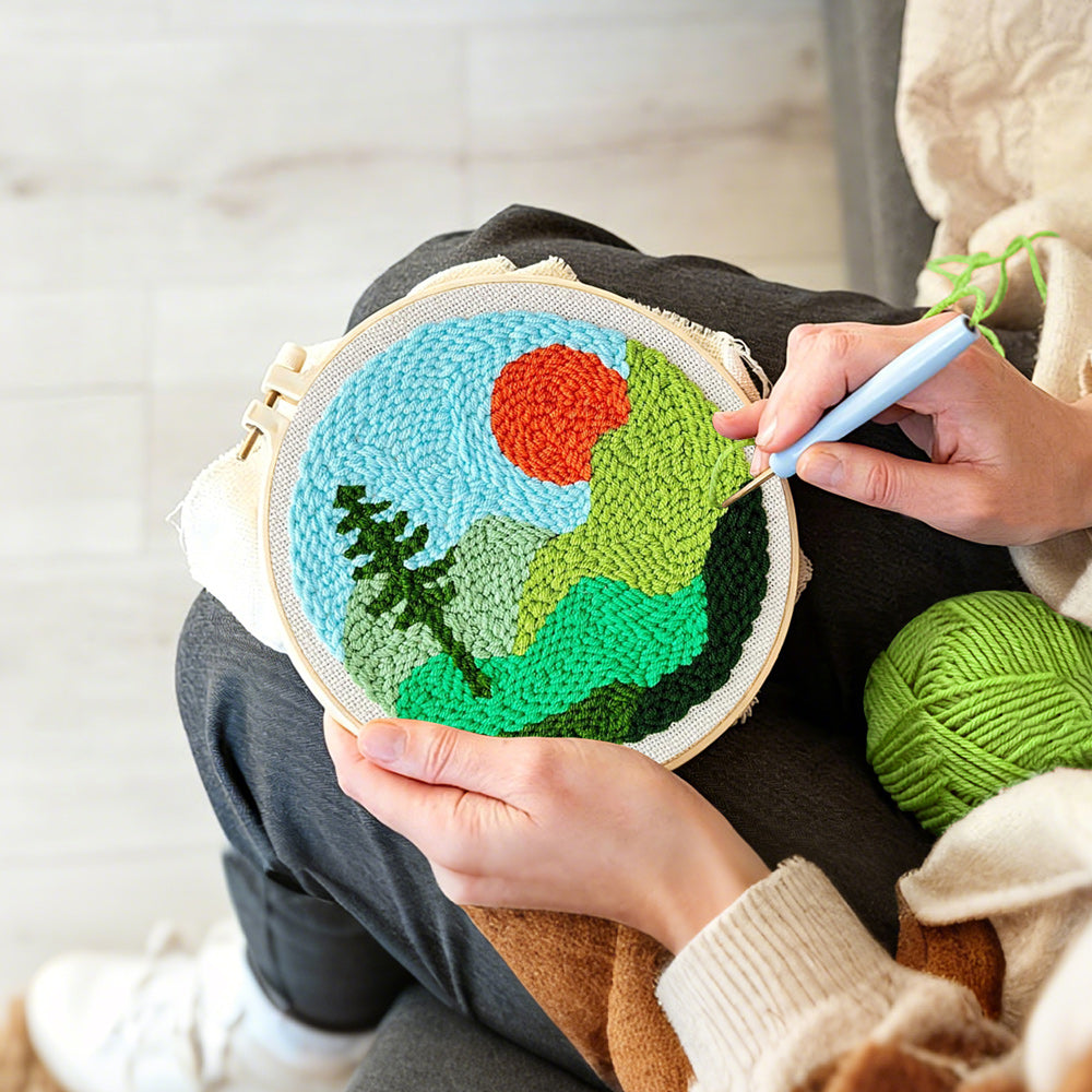 Creating handmade mountain landscape with sun and tree punch needle artwork
