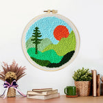 Finished mountain landscape with sun and tree artwork displayed on a wall