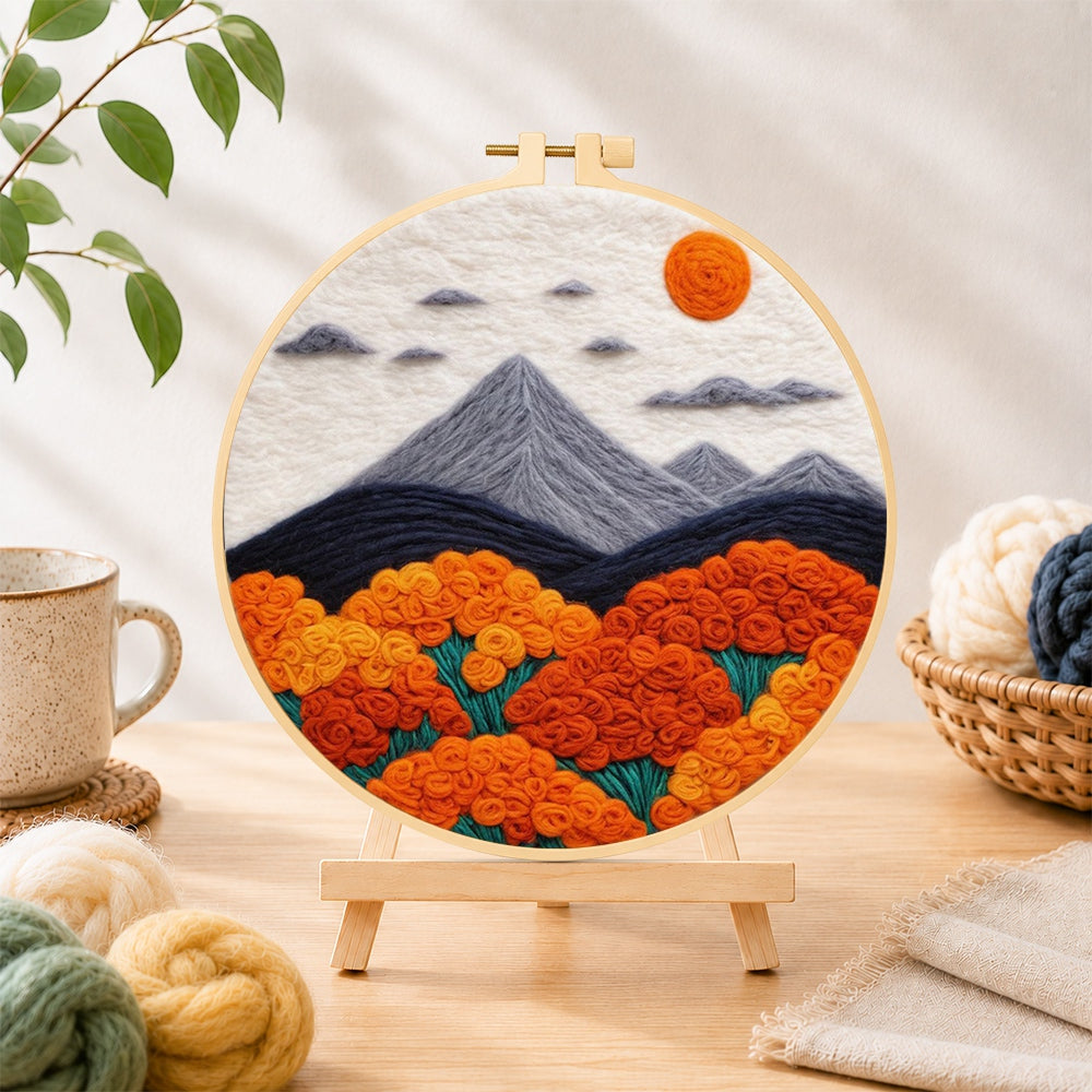 Finished mountains and lush orange roses needle felting displayed on a wooden easel