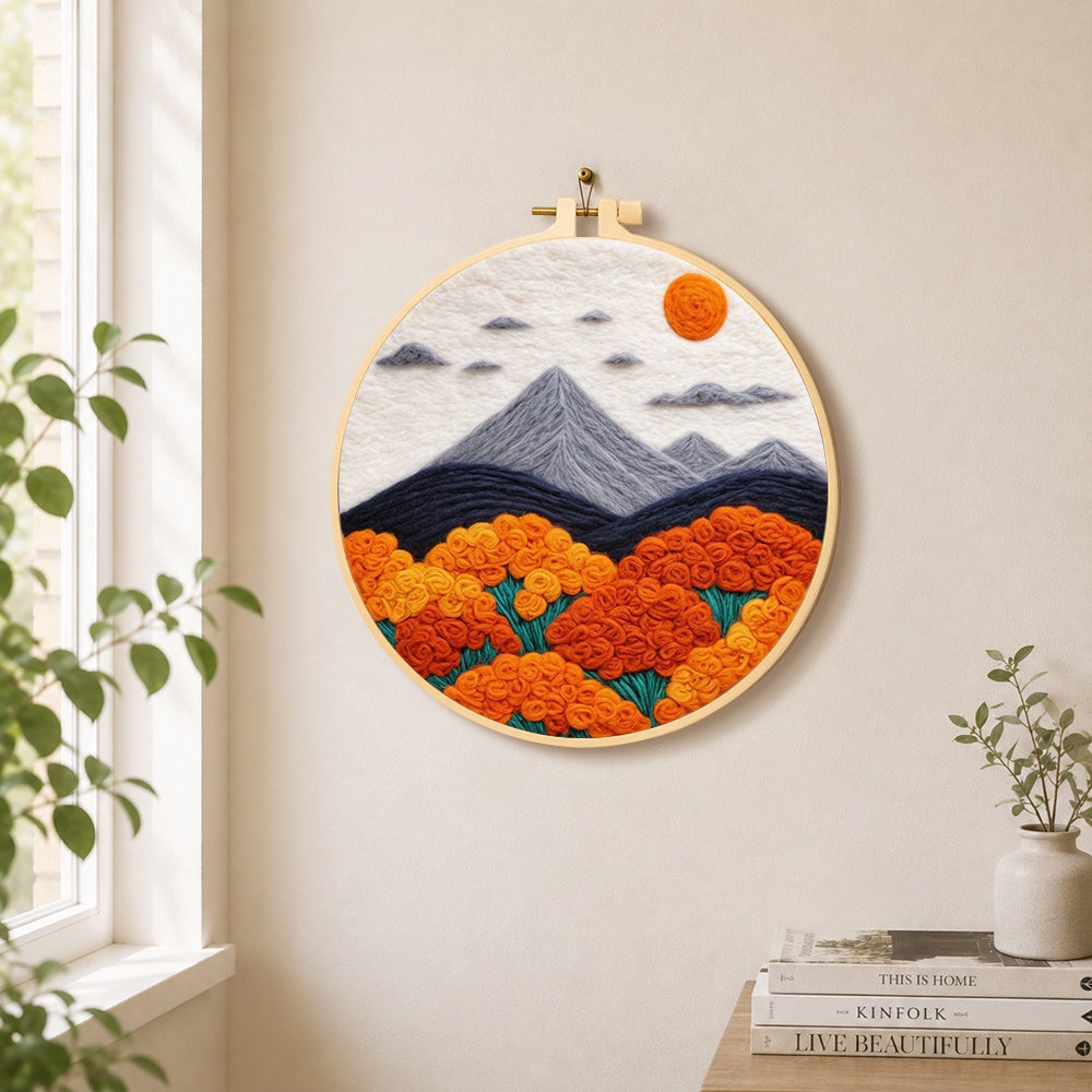 Mountains and lush orange roses needle felt wall art displayed in a bright home interior