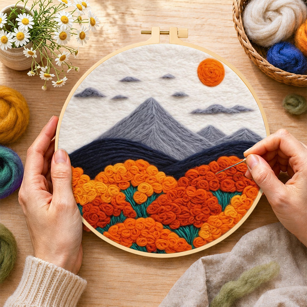 Creating the mountains and lush orange roses wool painting by hand with a felting needle