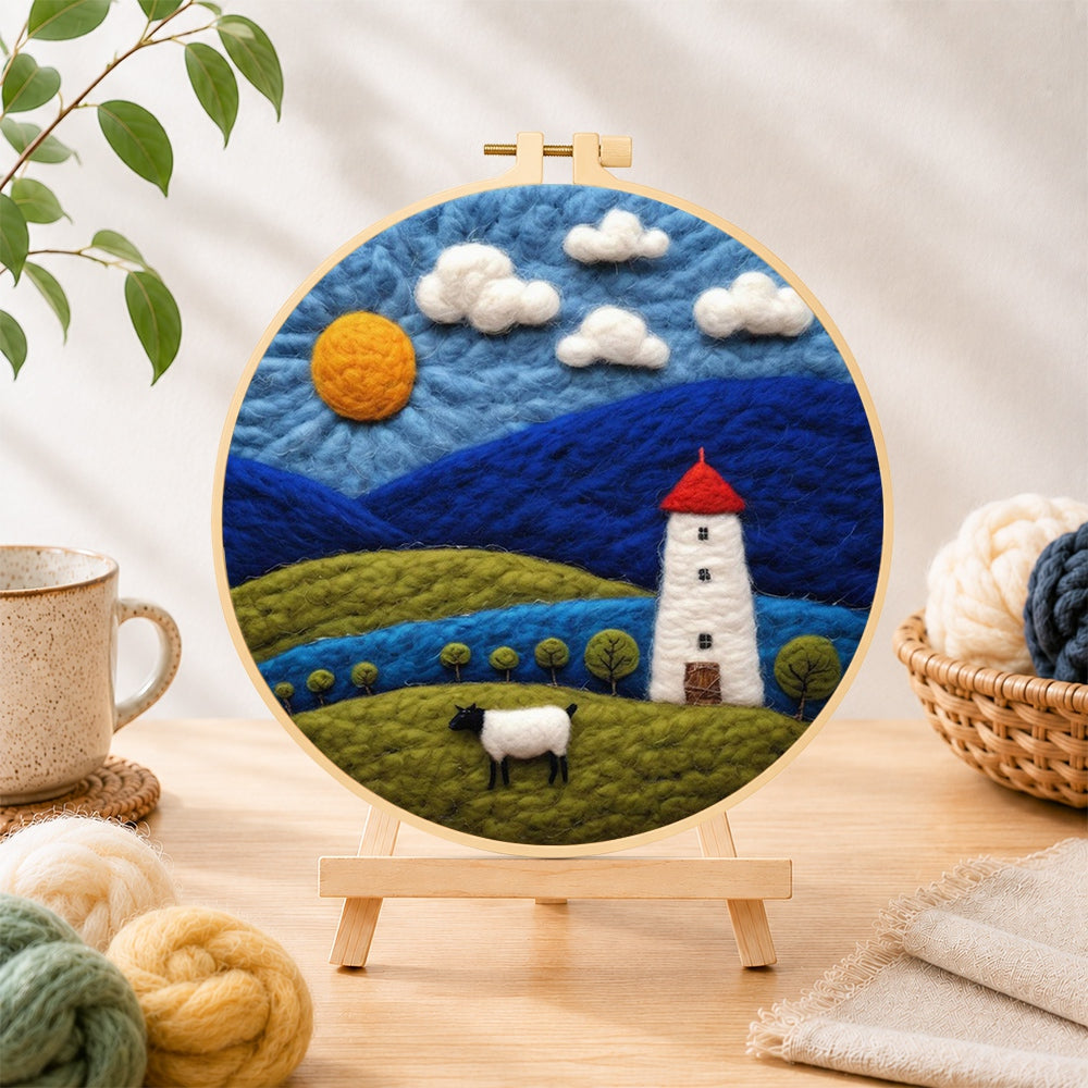 Finished mountains and white tower at night needle felting displayed on a wooden easel