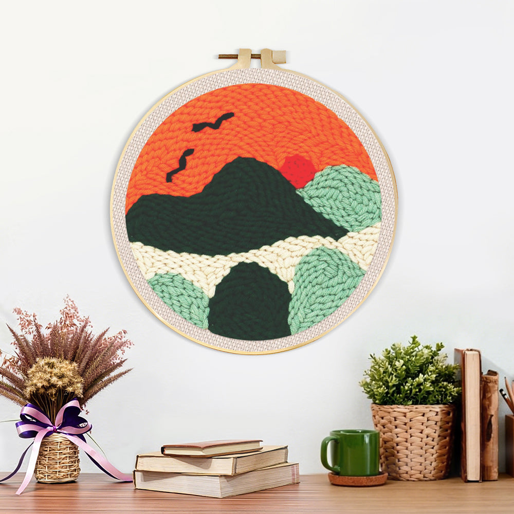 Finished mountains with flying birds at sunset artwork displayed on a wall