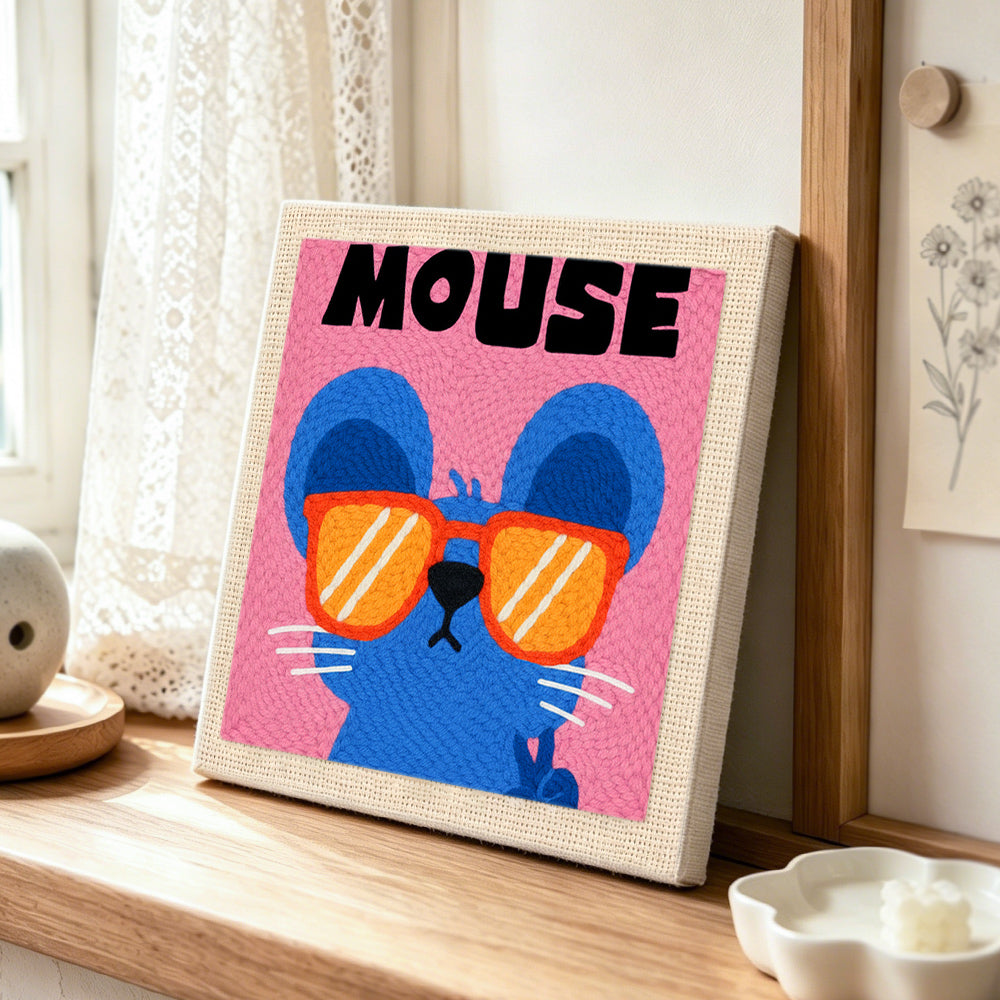 Mouse with sunglasses punch needle artwork displayed on a table