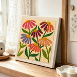 Multicolour daisies punch needle artwork displayed on a table