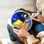 Creating handmade night scene with yellow-lit buildings punch needle artwork