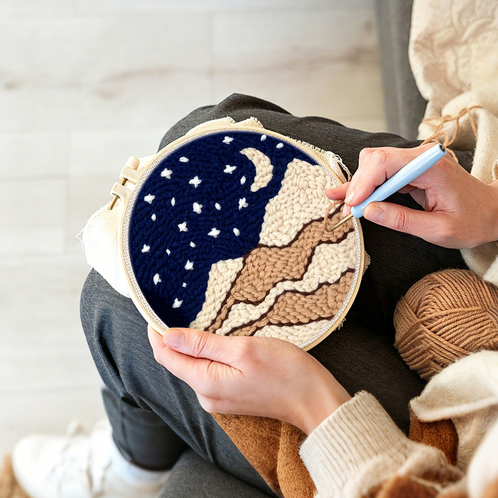 Creating handmade night sky with moon, stars and beige sand dunes punch needle artwork