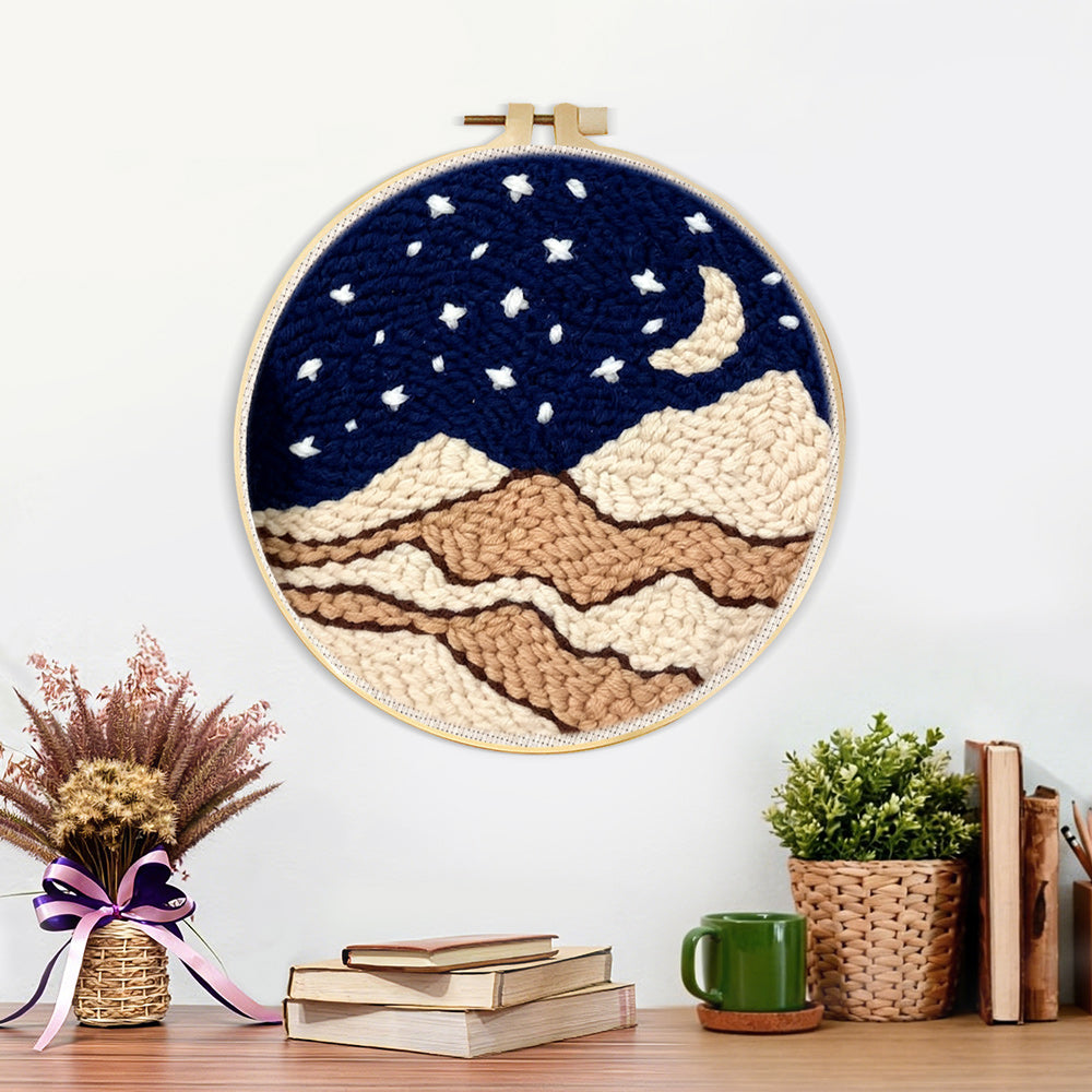 Finished night sky with moon, stars and beige sand dunes artwork displayed on a wall
