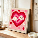Ombre heart with kawaii clouds punch needle artwork displayed on a table