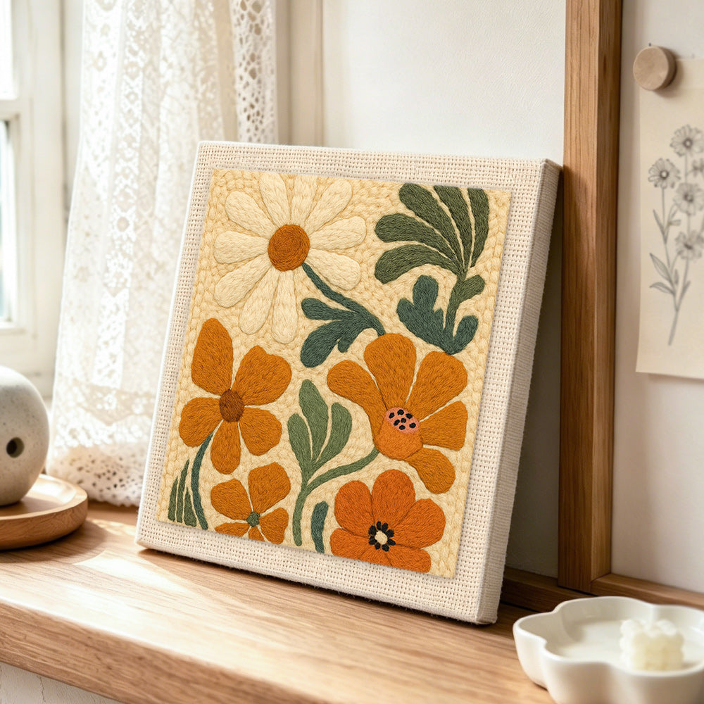 Orange and cream flowers punch needle artwork displayed on a table