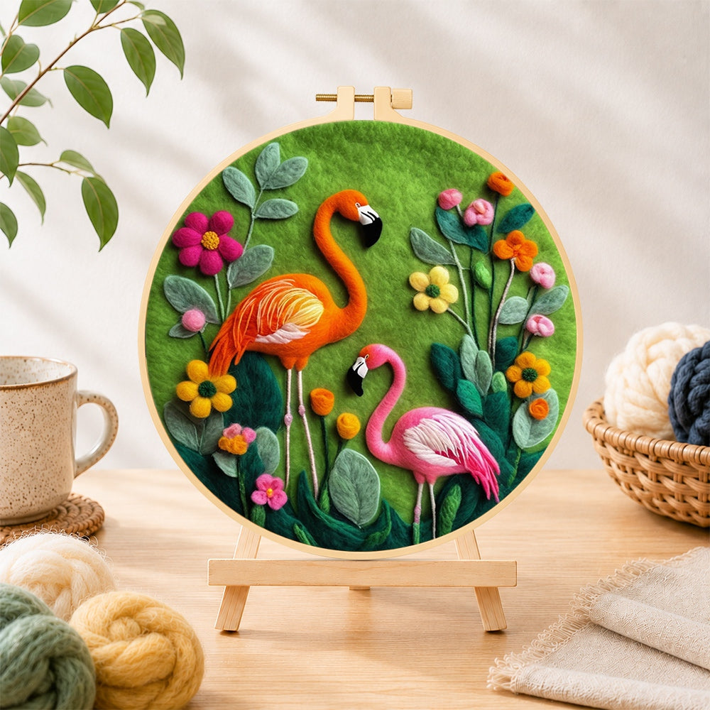 Finished orange and pink flamingos among flowers needle felting displayed on a wooden easel